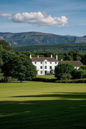 Castle in the middle of a green field with mountain in the backgroundの素材