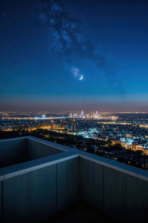 Night cityscape with starry sky and moon over the city.の素材