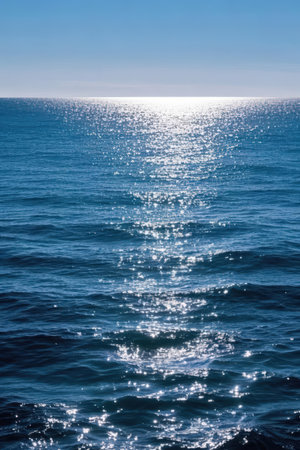 Blue sea water surface with sun rays and bokeh. Natural backgroundの素材