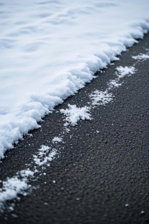 snow on the asphalt road in winter, closeup of photoの素材