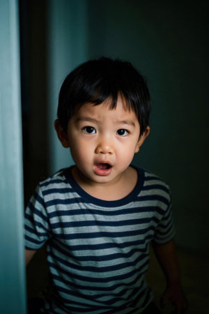 Cute asian baby boy crying in the dark room, closeup portraitの素材