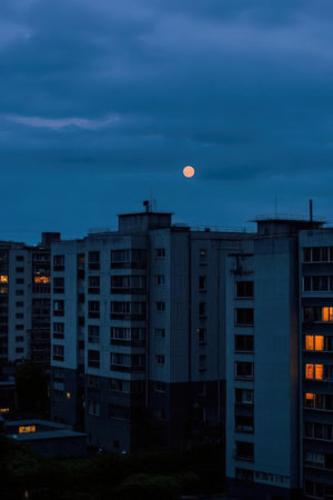 The moon rises over the city at night. The sky is blue.の素材