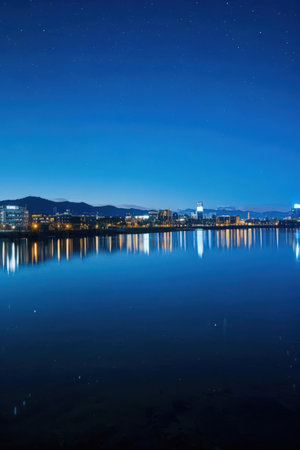 Night view of the city and the lake with starry sky.の素材