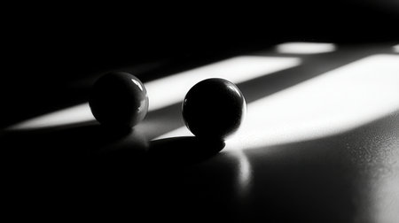 Black and white photo of two balls on a black background with shadowsの素材
