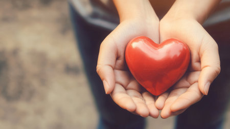 Woman holding red heart in her hands. Valentines day background.の素材