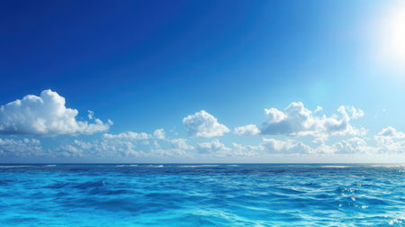 Blue sky with clouds and sun reflected in the water surface of the seaの素材