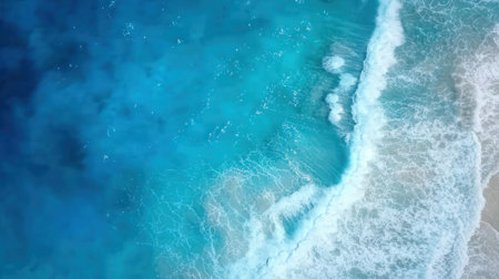 Aerial view of turquoise sea with waves and sand.の素材