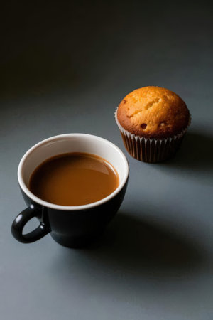 Cup of coffee and muffin on dark background, selective focusの素材