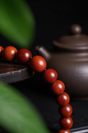 Wooden rosary beads and teapot on black backgroundの素材
