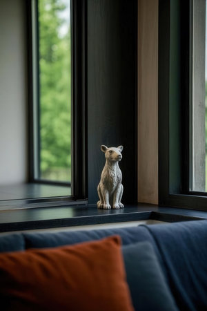 Cat sitting on a window sill in a room with a view of natureの素材