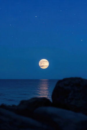 Full moon in the night sky over the sea. Long exposure.の素材