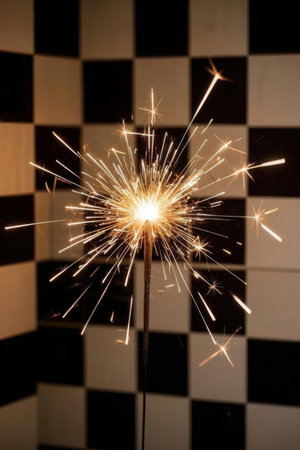 sparkler on black and white checkered chessboard backgroundの素材