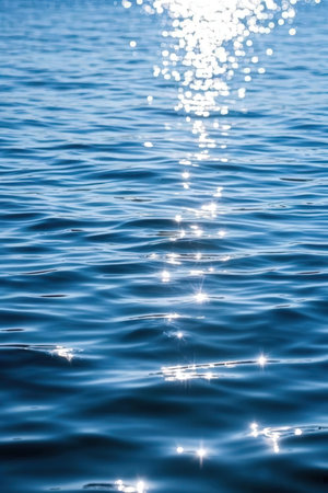 blue sea water surface with sun rays and bokeh - abstract backgroundの素材