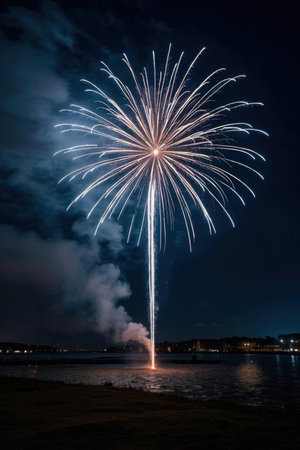 Beautiful firework show in the night sky with reflection on waterの素材