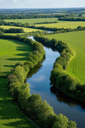 Aerial view of a river in the middle of a green fieldの素材