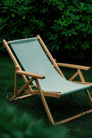 Wooden deck chair on green grass in the garden. Vacation concept.の素材