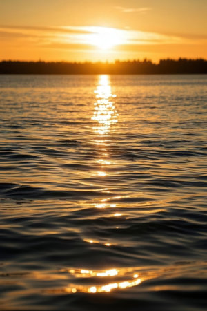 Beautiful sunset on the lake. The sun is reflected in the water.の素材