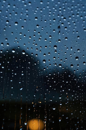 raindrops on the window glass at night, closeup of photoの素材