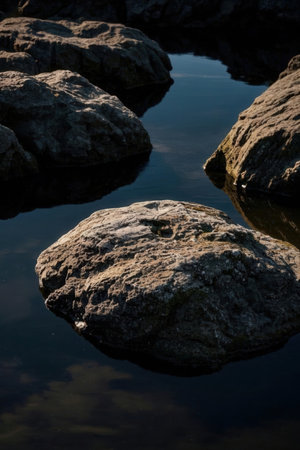 Rocks reflected in the water of a lake in the early morningの素材