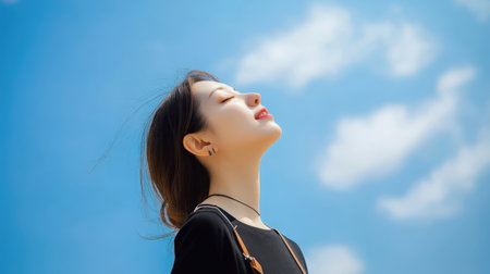 Portrait of young asian woman with blue sky and white cloudの素材