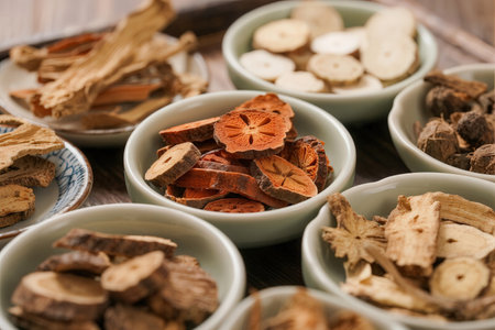 Slices of dried mushrooms in bowls on a wooden background.の素材