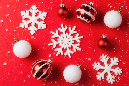 Christmas background with snowflakes and Christmas balls on a red backgroundの素材