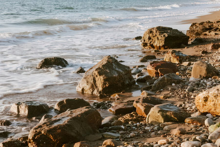 stones on the beach with waves and sea in the background, nature seriesの素材
