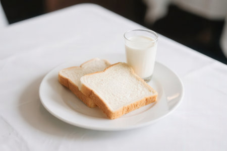 Breakfast with milk and bread on white plate, stock image.の素材