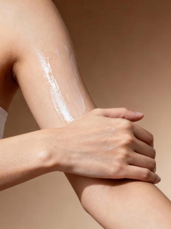 Woman applying moisturizing cream on her arm. Skin care concept.の素材