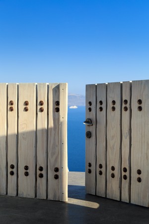 Beautiful view of the Caldera through the open wooden door at sunset.Santorini (Thira) island.Cyclades.Greece.Europeの写真素材