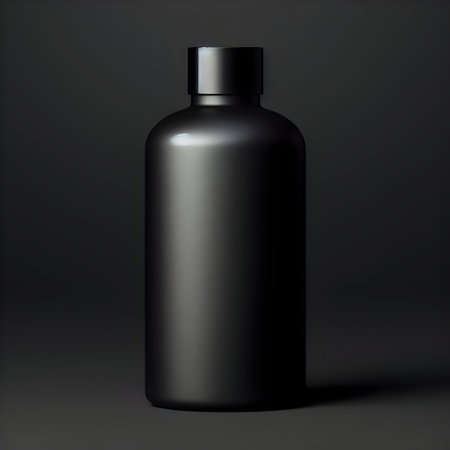 Mockup of a black cosmetic bottle on a dark background.の素材