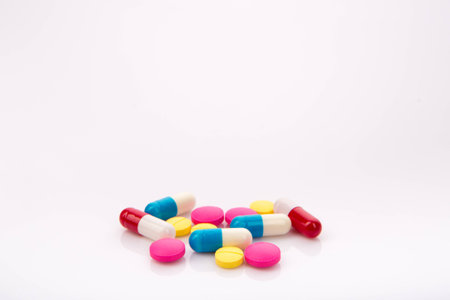 Pile of pills in white isolated background (drugs, manufacturing)の写真素材
