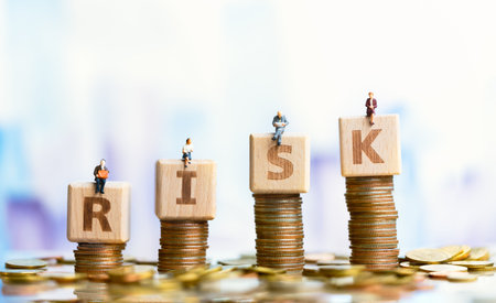 Miniature people: Elderly people sitting on word block risk. Retirement planning. money saving and...