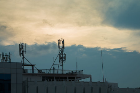 Siluate wifi and internet antenna on the building with sky background