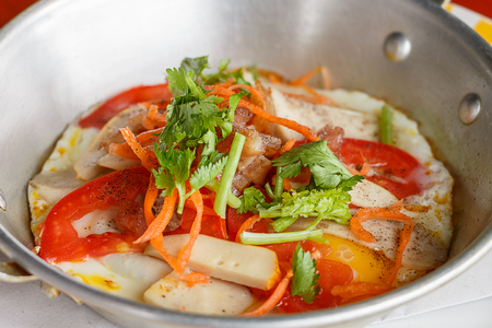 Close up pan-fried egg with pork and toppings on breakfast tradition of Northeast Thailandの写真素材