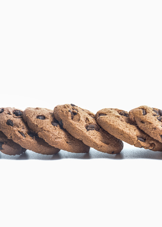 Close up chocolate chip cookies in row on isolated white backgroundの写真素材