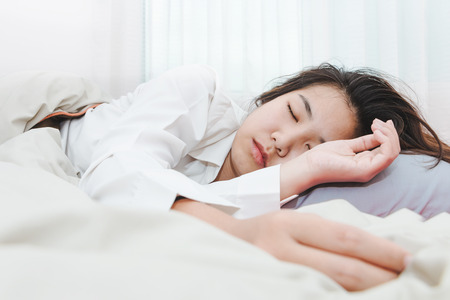 Young beautiful woman sleeping her bedの写真素材