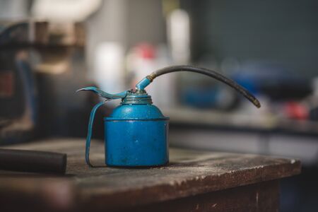 Old dirt and rusty can oil on the wooden table in the workshop.の写真素材