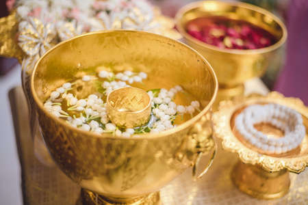 A set of the golden water bowl for holy water in the Thai wedding ceremony and the flower trays decoration.の写真素材