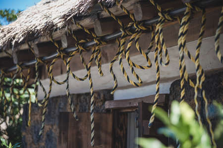 The scenery of the rope tied on the roof inside Seongeup Folk Village in Jeju Island, South Korea.の写真素材