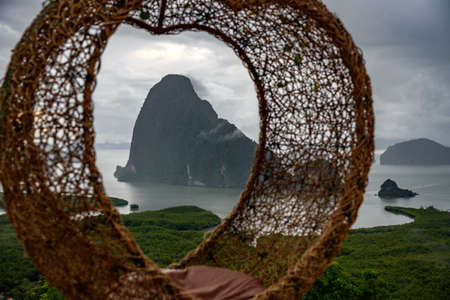 The scenery of the Sametnangshe island looks through the hanging basket wicker chair in Phang-nga province, Thailand.の写真素材