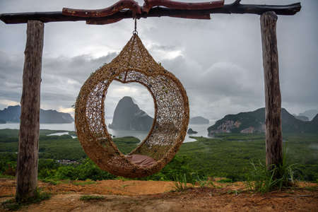 The scenery of the Sametnangshe island looks through the hanging basket wicker chair in Phang-nga province, Thailand.の写真素材