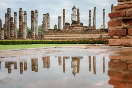 The scenery of the reflection of the buddha statue inside Wat Mahathat temple in Sukhothai historical park at Sukhothai province, Thailand.の写真素材
