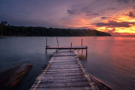 The long-exposure scenery of a beautiful twilight sky in sunset time over the wooden pier in Koh Kood island, Trat, Thailand.の写真素材