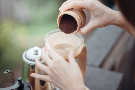 Hand drip coffee, Barista pouring the coffee ground in the filter.の写真素材