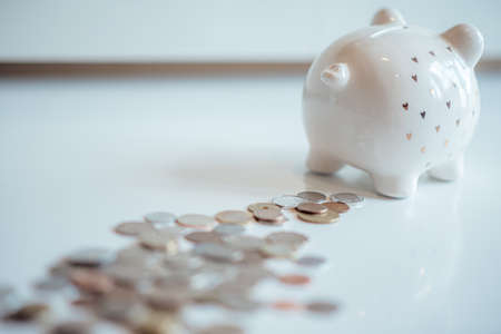 A run-away piggy bank leaving plenty of coins behind.の写真素材
