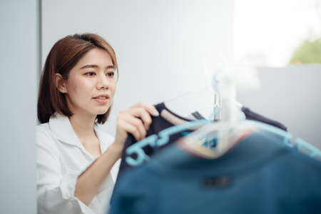 An Asian housewife is drying clothes on the rack after washing.の写真素材