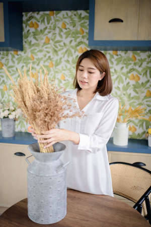 An Asian woman is arranging dried flowers.の写真素材
