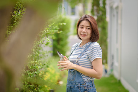 An Asian woman gardener portrait with a pruner.の写真素材