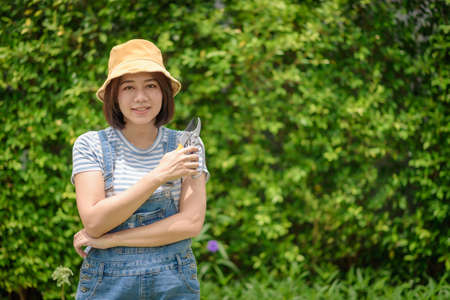 An Asian woman gardener portrait with a pruner.の写真素材